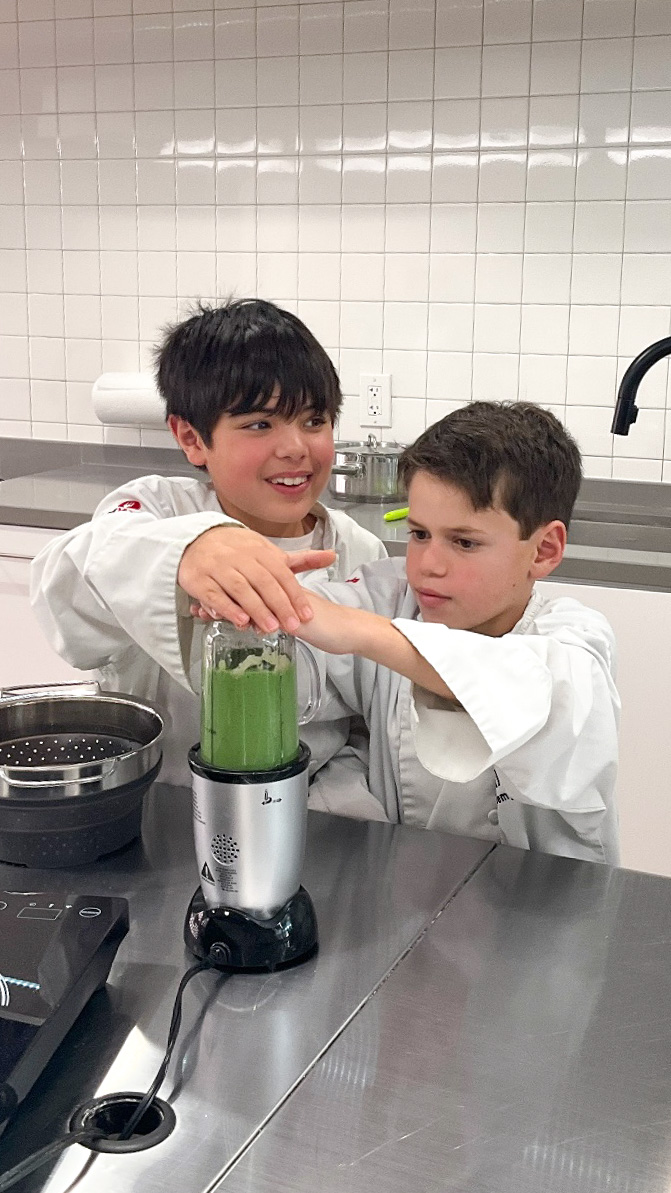 9 year old friends use blender during cooking class for kids