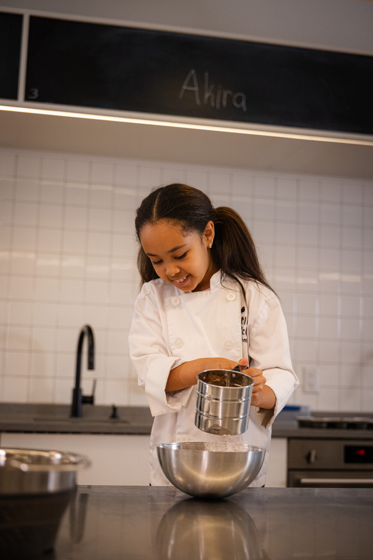 student sifting powdered sugar