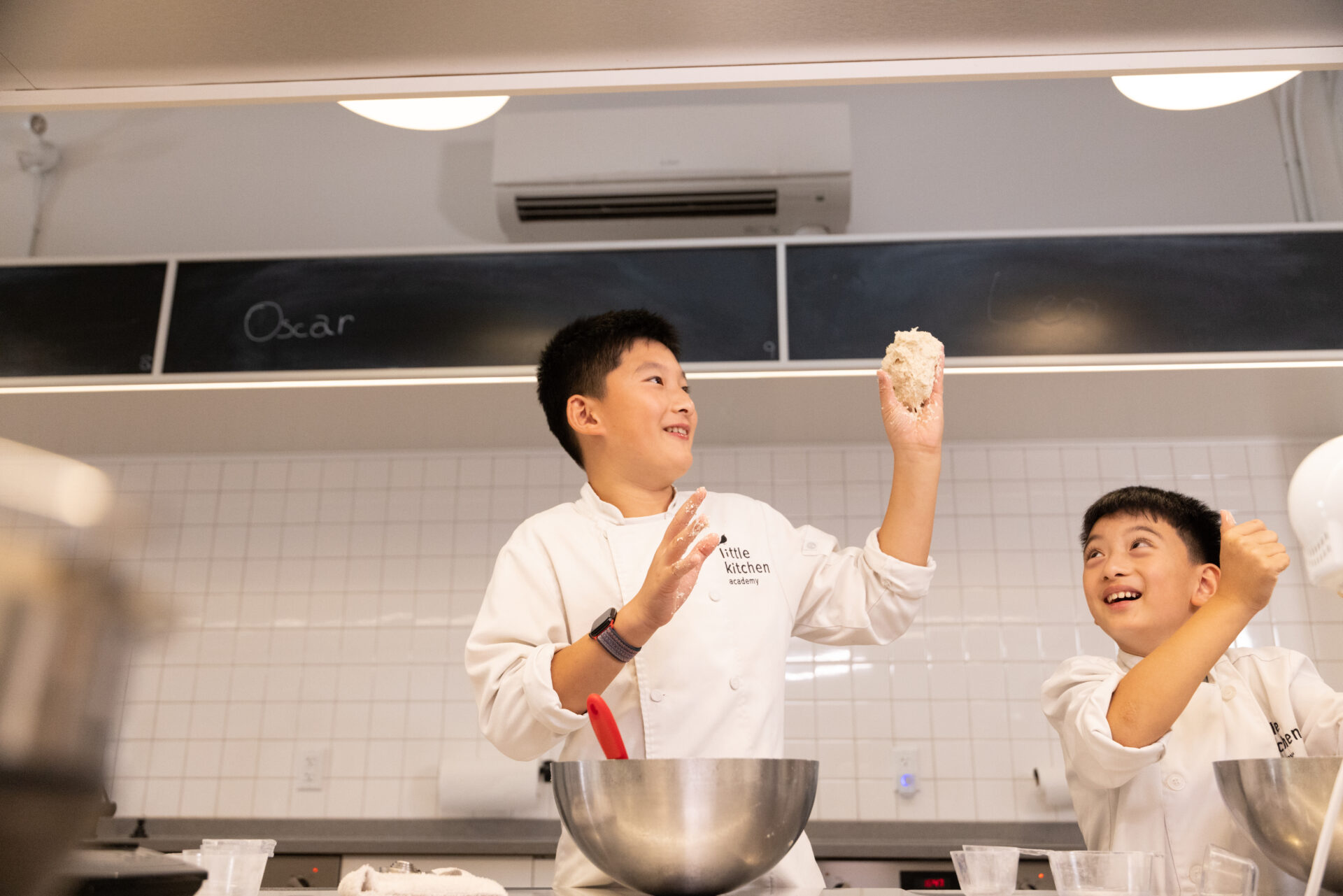 Students holding dough, learning math and science skills in the kitchen